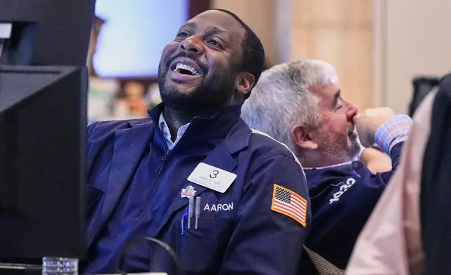 Traders Aaron Ford, left, and James McCarthy work on the floor of the New York Stock Exchange, Friday, Nov. 21, 2025. (AP Photo/Richard Drew)