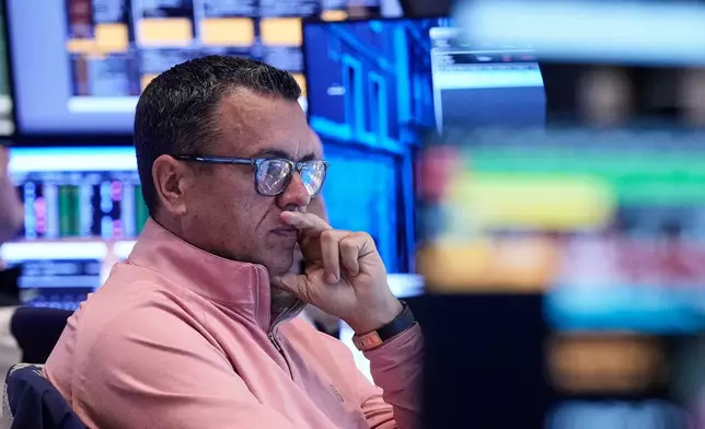 Trader Robert Finnerty Jr. works on the floor of the New York Stock Exchange, Friday, Nov. 21, 2025. (AP Photo/Richard Drew)