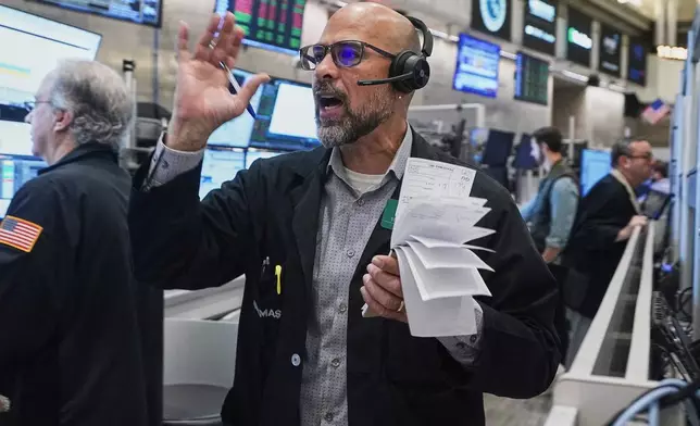 Options trader Steven Rodriguez works on the floor of the New York Stock Exchange, Friday, Nov. 21, 2025. (AP Photo/Richard Drew)
