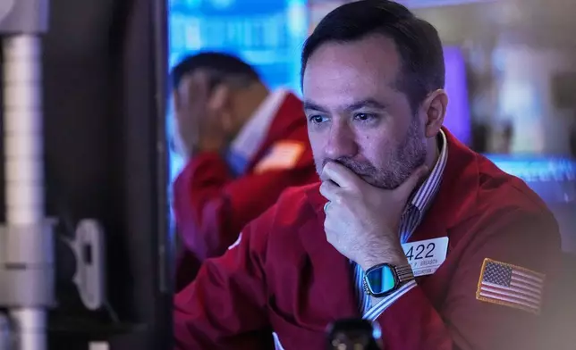 Trader Robert Greason works on the floor of the New York Stock Exchange, Friday, Nov. 14, 2025. (AP Photo/Richard Drew)