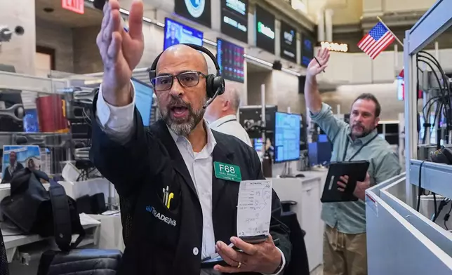Options traders Steven Rodriguez, left, and Scott Frenzy work on the floor of the New York Stock Exchange, Friday, Nov. 14, 2025. (AP Photo/Richard Drew)