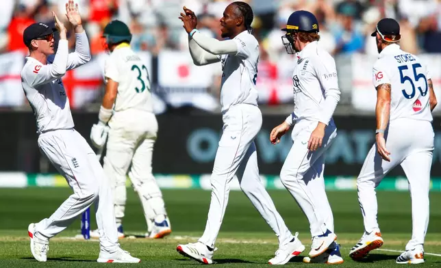 England's Jofra Archer, center, celebrates with teammates the wicket of Australia's Marnus Labuschagne during the first Ashes cricket test match between Australia and England in Perth, Friday, Nov. 21, 2025.(AP Photo/Gary Day)