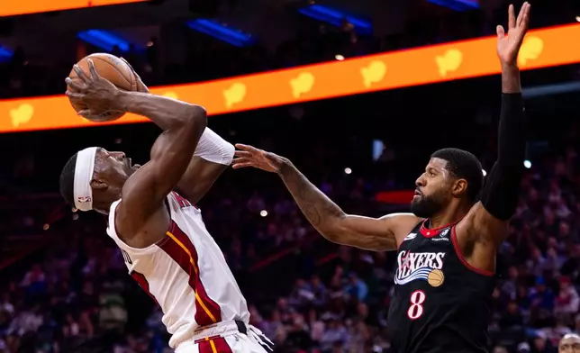 Miami Heat's Bam Adebayo, left, looks to shoot against Philadelphia 76ers' Paul George, right, during the first half of an NBA basketball game, Sunday, Nov. 23, 2025, in Philadelphia. (AP Photo/Chris Szagola)