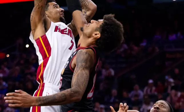 Miami Heat's Kel'el Ware, left, goes up to shoot against Philadelphia 76ers' Dom Barlow, center, during the first half of an NBA basketball game, Sunday, Nov. 23, 2025, in Philadelphia. (AP Photo/Chris Szagola)