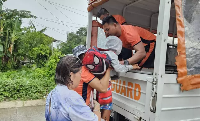 In this photo, provided by the Philippine Coast Guard, residents are evacuated to safer grounds as Typhoon Kalmaegi nears the area of Guiuan, Eastern Samar province, central Philippines on Monday Nov. 3, 2025. (Philippine Coast Guard via AP)