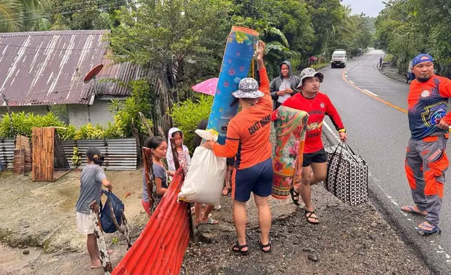 In this photo, provided by the Philippine Coast Guard, residents are evacuated to safer grounds as Typhoon Kalmaegi nears the area of San Julian, Eastern Samar province, central Philippines on Monday Nov. 3, 2025. (Philippine Coast Guard via AP)