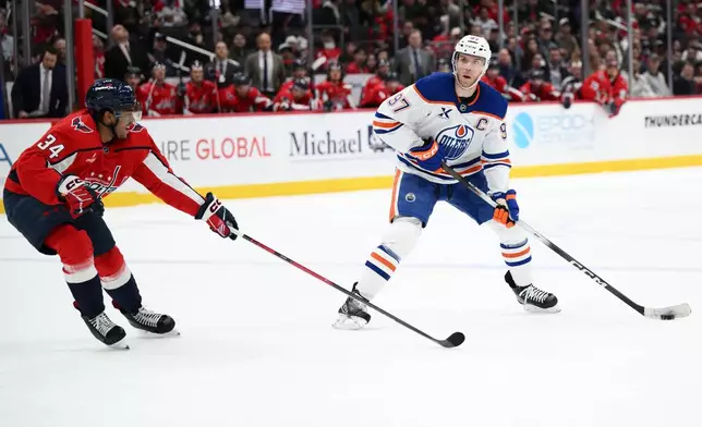 Edmonton Oilers center Connor McDavid (97) skates with the puck against Washington Capitals right wing Justin Sourdif (34) during the second period of an NHL hockey game, Wednesday, Nov. 19, 2025, in Washington. (AP Photo/Nick Wass)