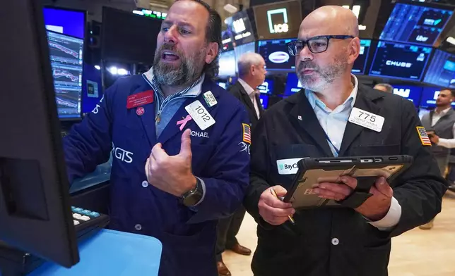 Specialist Michael Pistillo, left, and trader Fred Demarco work on the floor of the New York Stock Exchange, Thursday, Nov. 20, 2025. (AP Photo/Richard Drew)