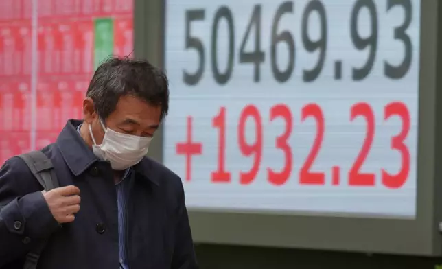 A person walks in front of an electronic stock board showing Japan's Nikkei index at a securities firm Thursday, Nov. 20, 2025, in Tokyo. (AP Photo/Eugene Hoshiko)