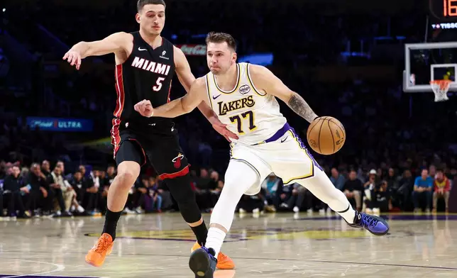 Los Angeles Lakers guard Luka Doncic (77) drives against Miami Heat forward Nikola Jovic (5) during the first half of an NBA basketball game, Sunday, Nov. 2, 2025, in Los Angeles. (AP Photo/Jessie Alcheh)