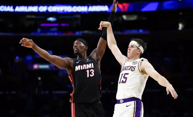 Los Angeles Lakers guard Austin Reaves (15) follows through on a 3-point basket as Miami Heat center Bam Adebayo (13) watches during the first half of an NBA basketball game, Sunday, Nov. 2, 2025, in Los Angeles. (AP Photo/Jessie Alcheh)