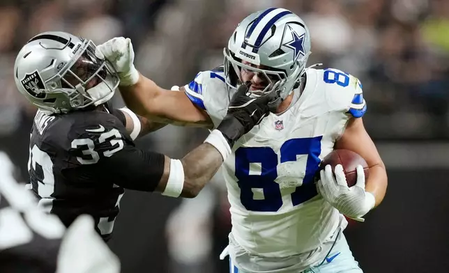 Dallas Cowboys tight end Jake Ferguson (87) tries to push Las Vegas Raiders linebacker Jamal Adams (33) aside during the second half of an NFL football game Monday, Nov. 17, 2025, in Las Vegas. (AP Photo/John Locher)