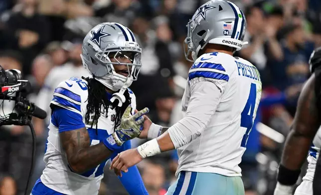 Dallas Cowboys wide receiver CeeDee Lamb, left, celebrates his touchdown against the Las Vegas Raiders with Cowboys quarterback Dak Prescott (4) during the first half of an NFL football game Monday, Nov. 17, 2025, in Las Vegas. (AP Photo/David Becker)