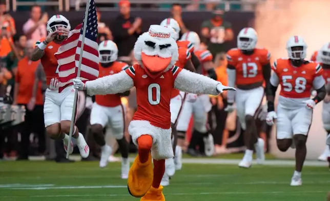 FILE - Miami mascot, Sebastian the Ibis, leads the team onto the field before the start of an NCAA college football game against Ohio, Sept. 1, 2023, in Miami Gardens, Fla. (AP Photo/Wilfredo Lee, File)
