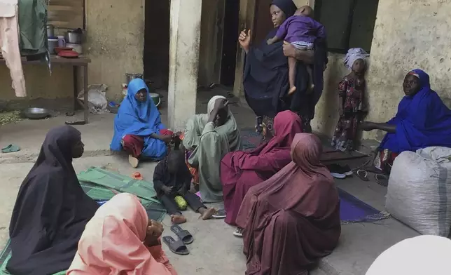 Amina Hassan, standing, wife of the vice principal of the Government Girls Comprehensive Secondary School, where gunmen on Monday attacked the school dormitory, abducted schoolgirls and killed her husband, with mourners, in Kebbi, Nigeria, Tuesday, Nov. 18, 2025. (AP Photo/Tunde Omolehin)