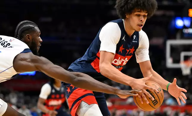 Dallas Mavericks Moussa Cisse, left, knocks the ball loose from the hands of Washington Wizards forward Kyshawn George during the first half of an NBA basketball game Saturday, Nov. 8, 2025, in Washington. (AP Photo/John McDonnell)