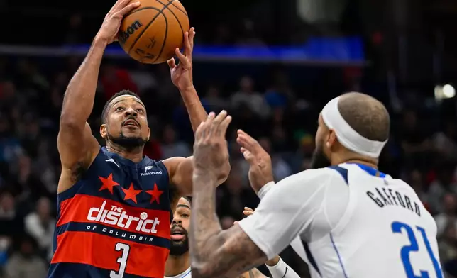 Washington Wizards guard CJ McCollum (3) rises over Dallas Mavericks forward Daniel Gafford (21) for a basket during the first half of an NBA basketball game Saturday, Nov. 8, 2025, in Washington. (AP Photo/John McDonnell)