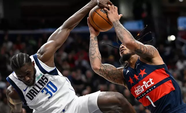 Dallas Mavericks Moussa Cisse, left, blocks the shot of Washington Wizards forward Cam Whitmore during the first half of an NBA basketball game Saturday, Nov. 8, 2025, in Washington. (AP Photo/John McDonnell)