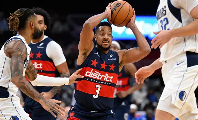 Washington Wizards guard CJ McCollum (3) passes off during the first half of an NBA basketball game against the Dallas Mavericks, Saturday, Nov. 8, 2025, in Washington. (AP Photo/John McDonnell)