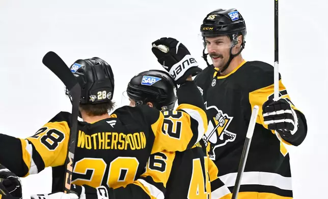 Pittsburgh's Parker Wotherspoon is congratulated by teammates Blake Lizotte and Erik Karlsson after his 1-0 goal during the NHL Global Series hockey game between the Pittsburgh Penguins and the Nashville Predators in Stockholm, Sweden, Sunday, Nov. 16, 2025. (Claudio Bresciani/TT News Agency via AP)