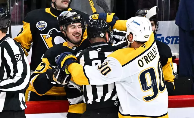 Penguin's Sidney Crosby scuffles with Predator's Ryan O'Reilly, right, during the NHL Global Series hockey game between the Pittsburgh Penguins and the Nashville Predators in Stockholm, Sweden, Sunday, Nov. 16, 2025. (Claudio Bresciani/TT News Agency via AP)