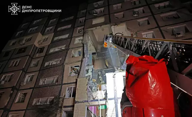 In this photo provided by the Ukrainian Emergency Service, firefighters put out the fire following a Russian rocket attack that hit a multi-storey apartment building in Dnipro, Ukraine, Saturday, Nov. 8, 2025. (Ukrainian Emergency Service via AP)