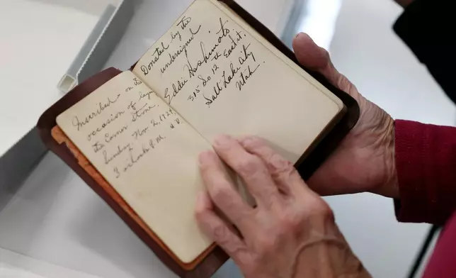 Joy Hashimoto Douglass holds a Bible donated in 1924 by her father, Eddie Hashimoto, and included in the contents of the Japanese Church of Christ's 100-year-old time capsule that was recently opened at the University of Utah Marriott Library Preservation Department in Salt Lake City, Monday, Oct. 20, 2025. (Kristin Murphy/The Deseret News via AP)
