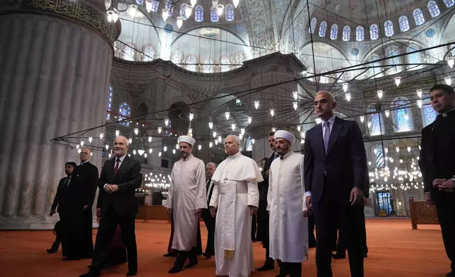 Pope Leo XIV, center, walking with Muezzin Musa Asgın Tunca, left, Dr. Emrullah Tuncel, second from left, Imam of Mosque Sultanahmet Fatih Kaya, and Turkish Minister for Culture and Tourism Mehmet Nuri Ersoy, visits the Sultan Ahmed Mosque in Istanbul, Saturday, Nov. 29, 2025. (AP Photo/Domenico Stinellis)