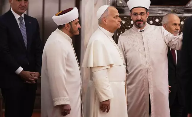 Pope Leo XIV, center, visits the Sultan Ahmed Mosque in Istanbul, Saturday, Nov. 29, 2025. (AP Photo/Domenico Stinellis)
