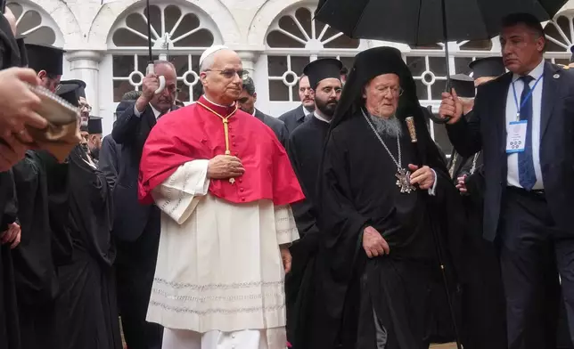 Pope Leo XIV and Ecumenical Patriarch Bartholomew I, the spiritual leader of the world's Eastern Orthodox Christians leave after a doxology service at the Patriarchal Church of Saint George, in Istanbul, Turkey, Saturday, Nov. 29, 2025. (AP Photo/Francisco Seco)