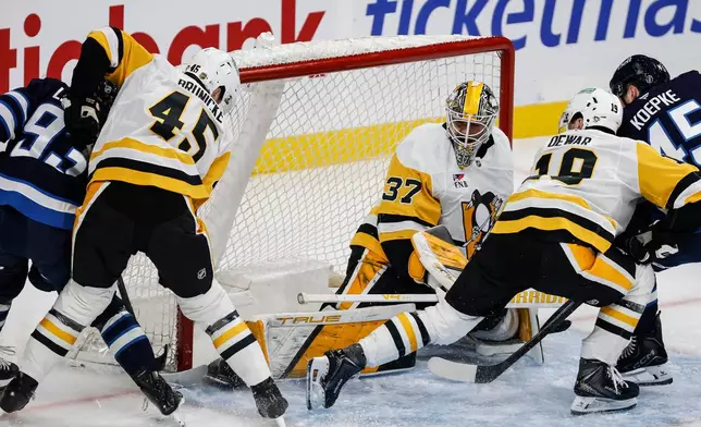 Winnipeg Jets' Brad Lambert (93) scores on Pittsburgh Penguins goaltender Arturs Silovs (37) as Harrison Brunicke (45) and Connor Dewar (19) defend during the first period of an NHL hockey game, Saturday, Nov. 1, 2025, in Winnipeg, Manitoba. (John Woods/The Canadian Press via AP)