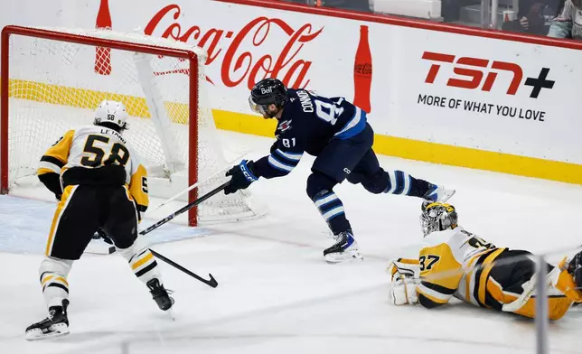 Pittsburgh Penguins goaltender Arturs Silovs (37) who was caught out of his net, throws his stick at Winnipeg Jets' Kyle Connor (81) during the second period of an NHL hockey game, Saturday, Nov. 1, 2025, in Winnipeg, Manitoba. (John Woods/The Canadian Press via AP)