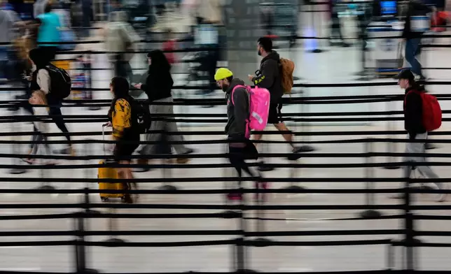 Travelers make their way through security lines at the Nashville International Airport, Tuesday, Nov. 25, 2025, in Nashville, Tenn. (AP Photo/George Walker IV)