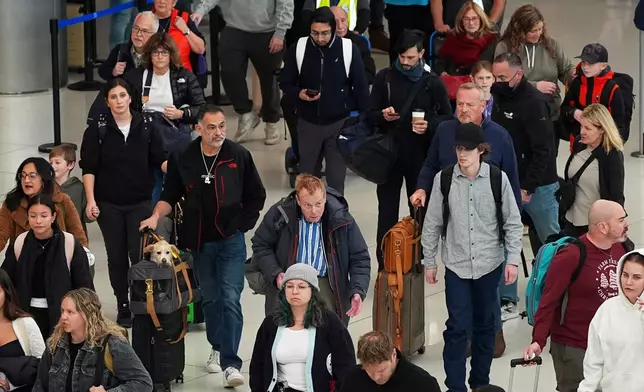 Travelers move through the main terminal of Denver International Airport, Tuesday, Nov. 25, 2025, in Denver. (AP Photo/David Zalubowski)