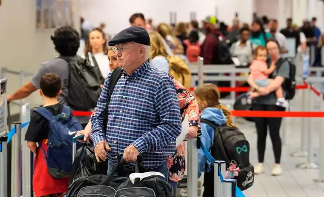 Travelers stand in line at a ticketing gate at the Dallas Fort Worth International Airport, at DFW Airport, Texas, Friday, Nov. 21, 2025. (AP Photo/Tony Gutierrez)