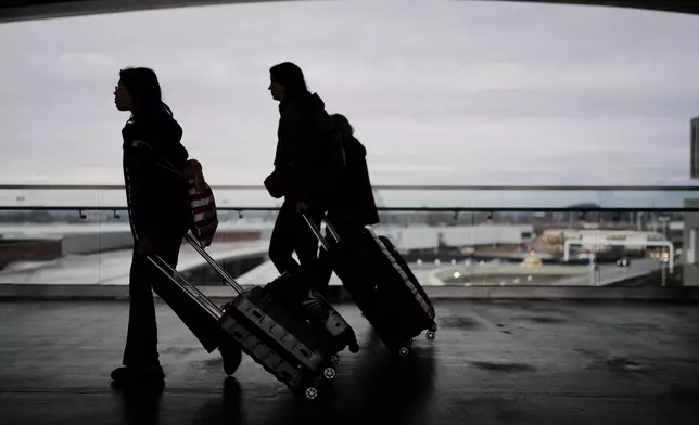 Travelers make their way through the Nashville International Airport, Tuesday, Nov. 25, 2025, in Nashville, Tenn. (AP Photo/George Walker IV)