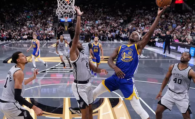 Golden State Warriors forward Jimmy Butler III (10) shoots past San Antonio Spurs guard De'Aaron Fox (4) during the second half of an NBA Cup basketball game in San Antonio, Friday, Nov. 14, 2025. (AP Photo/Eric Gay)