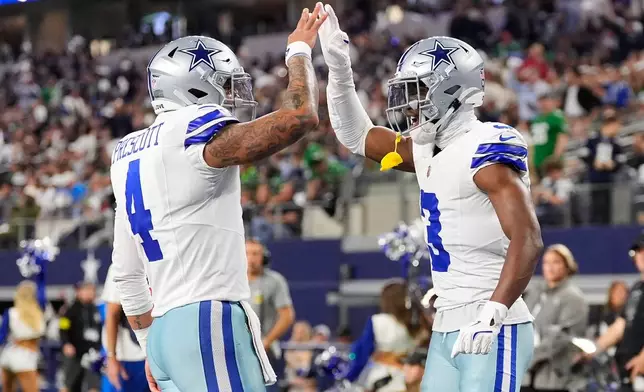 Dallas Cowboys wide receiver George Pickens (3) celebrates his touchdown catch with quarterback Dak Prescott (4) during the first half of an NFL football game Sunday, Nov. 23, 2025, in Arlington, Texas. (AP Photo/Tony Gutierrez)