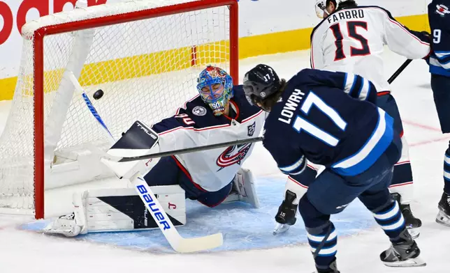 Winnipeg Jets' Adam Lowry (17) scores on Columbus Blue Jackets goaltender Elvis Merzlikins (90) during the first period of an NHL hockey game in Winnipeg, Manitoba, Tuesday Nov. 18, 2025. (Fred Greenslade/The Canadian Press via AP)