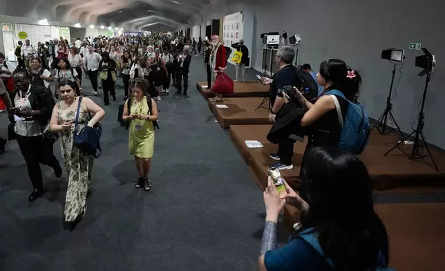 Attendees exit the venue for the COP30 U.N. Climate Summit, Thursday, Nov. 20, 2025, in Belem, Brazil. (AP Photo/Fernando Llano)