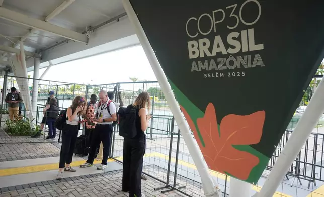 Attendees stand outside the venue for the COP30 U.N. Climate Summit after they were asked to leave, Thursday, Nov. 20, 2025, in Belem, Brazil. (AP Photo/Fernando Llano)