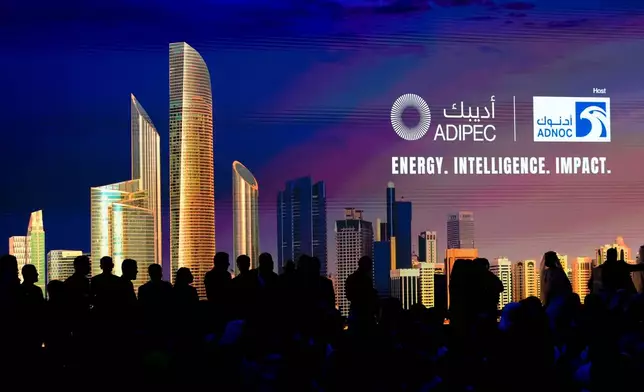 Delegates are silhouetted against a screen as they attend the inaugural session of the annual Abu Dhabi International Petroleum Exhibition and Conference (ADIPEC), in Abu Dhabi, United Arab Emirates, Monday, Nov. 3, 2025. (AP Photo/Altaf Qadri)