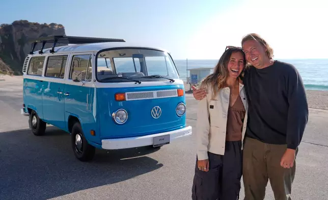 Megan Krystle Weinraub, left, and Preston Martin, who is the former owner, pose in front of her Volkswagen bus after seeing it for the first time Monday, Oct. 27, 2025, in Malibu, Calif., after it was restored by VW. (AP Photo/Mark J. Terrill)