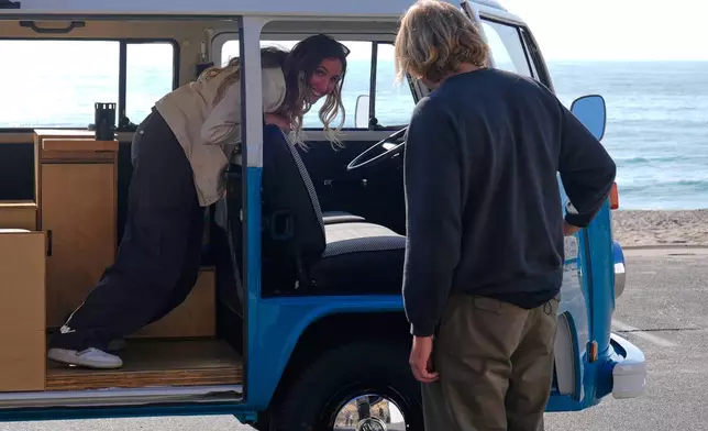 Megan Krystle Weinraub, left, and Preston Martin, who is the former owner, look over her Volkswagen bus as they see it for the first time Monday, Oct. 27, 2025, in Malibu, Calif., after it was restored by VW. (AP Photo/Mark J. Terrill)