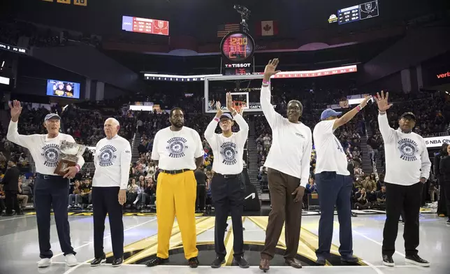 Members of the 1974-1975 Golden State Warriors NBA Championship team wave during a ceremony at the first half of the NBA Cup basketball game against the Portland Trail Blazers in San Francisco, Friday, Nov. 21, 2025. (Stephen Lam/San Francisco Chronicle via AP)