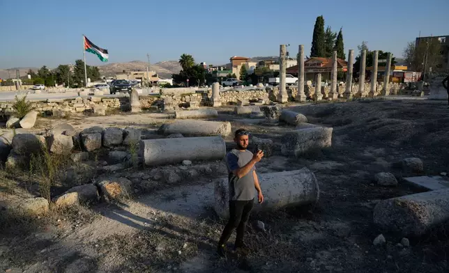 A Palestinian visitor takes a photo at the Roman historical site in the West Bank town of Sebastia Thursday, Nov. 20, 2025. (AP Photo/Nasser Nasser)
