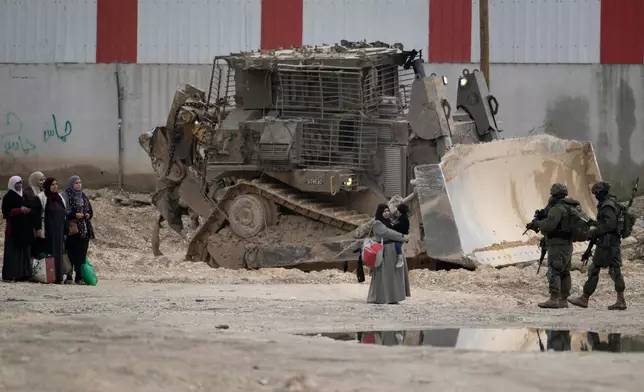 FILE -Israeli soldiers check the identification cards of Palestinians while they evacuate their homes in the West Bank refugee camp of Nur Shams, near Tulkarem, while the Israeli military operation continues in the area on, Feb. 11, 2025. (AP Photo/Majdi Mohammed, File)
