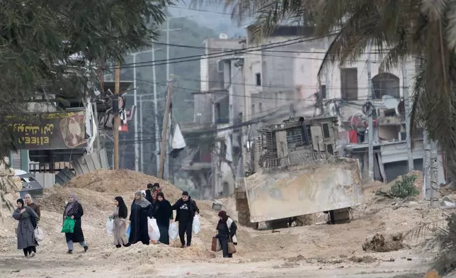 FILE -Residents of the West Bank refugee camp of Nur Shams, near Tulkarem, evacuate their homes as the Israeli military continues its operation in the area on Feb. 11, 2025. (AP Photo/Majdi Mohammed, File)