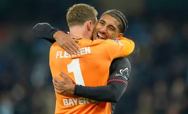 Leverkusen's Loic Balde hugs Leverkusen's goalkeeper Mark Flekken after the end of the Champions League opening phase soccer match between Manchester City and Bayer Leverkusen in Manchester, England, Tuesday, Nov. 25, 2025. (AP Photo/Dave Thompson)