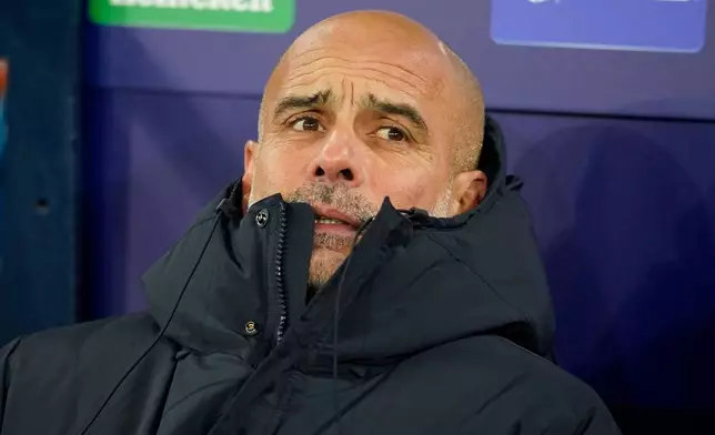 Manchester City's head coach Pep Guardiola sits in the dug out ahead of the Champions League opening phase soccer match between Manchester City and Bayer Leverkusen in Manchester, England, Tuesday, Nov. 25, 2025. (AP Photo/Dave Thompson)
